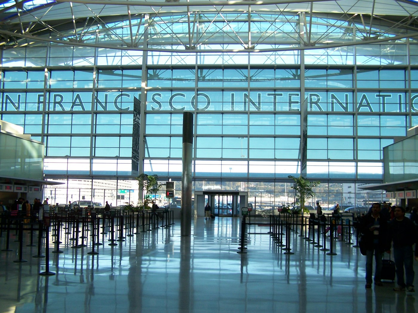 旧金山国际机场 SFO 航站楼内部，玻璃墙上写着 SAN FRANCISCO INTERNATIONAL